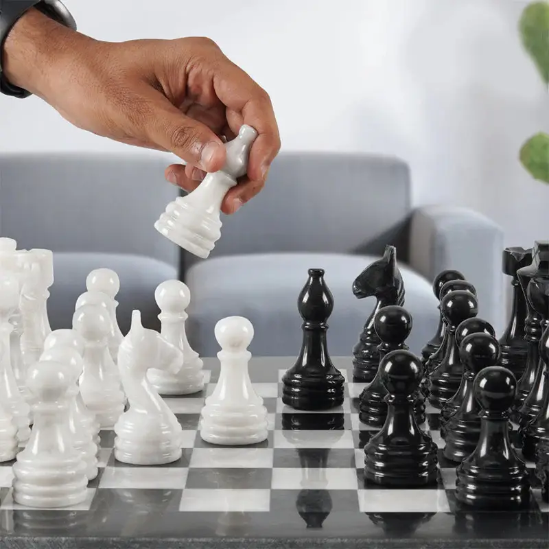 Person playing with black and white chess pieces