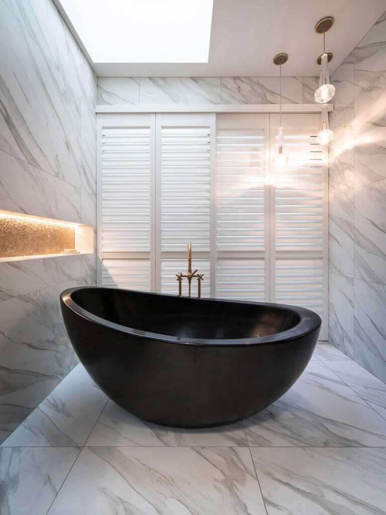 Elegant bathroom with black freestanding tub and marble walls