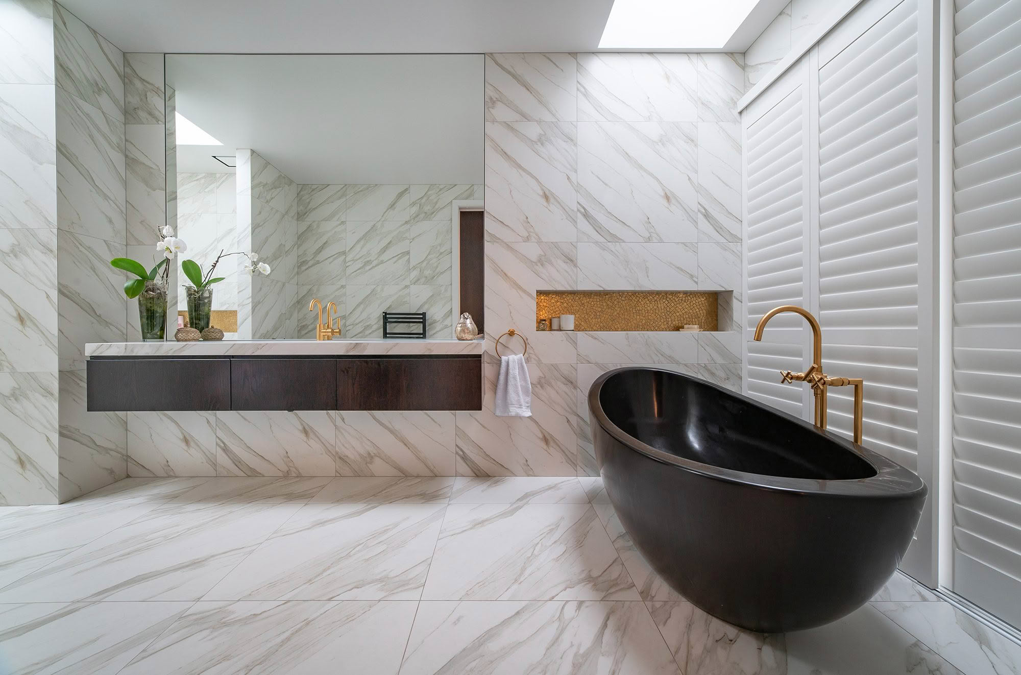 Modern bathroom with marble walls and black bathtub