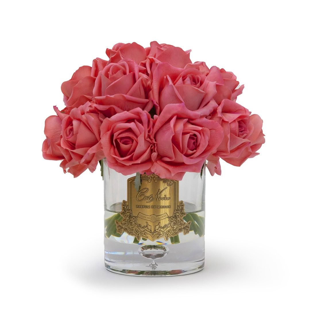Coral roses in glass vase with Costa Mesa label