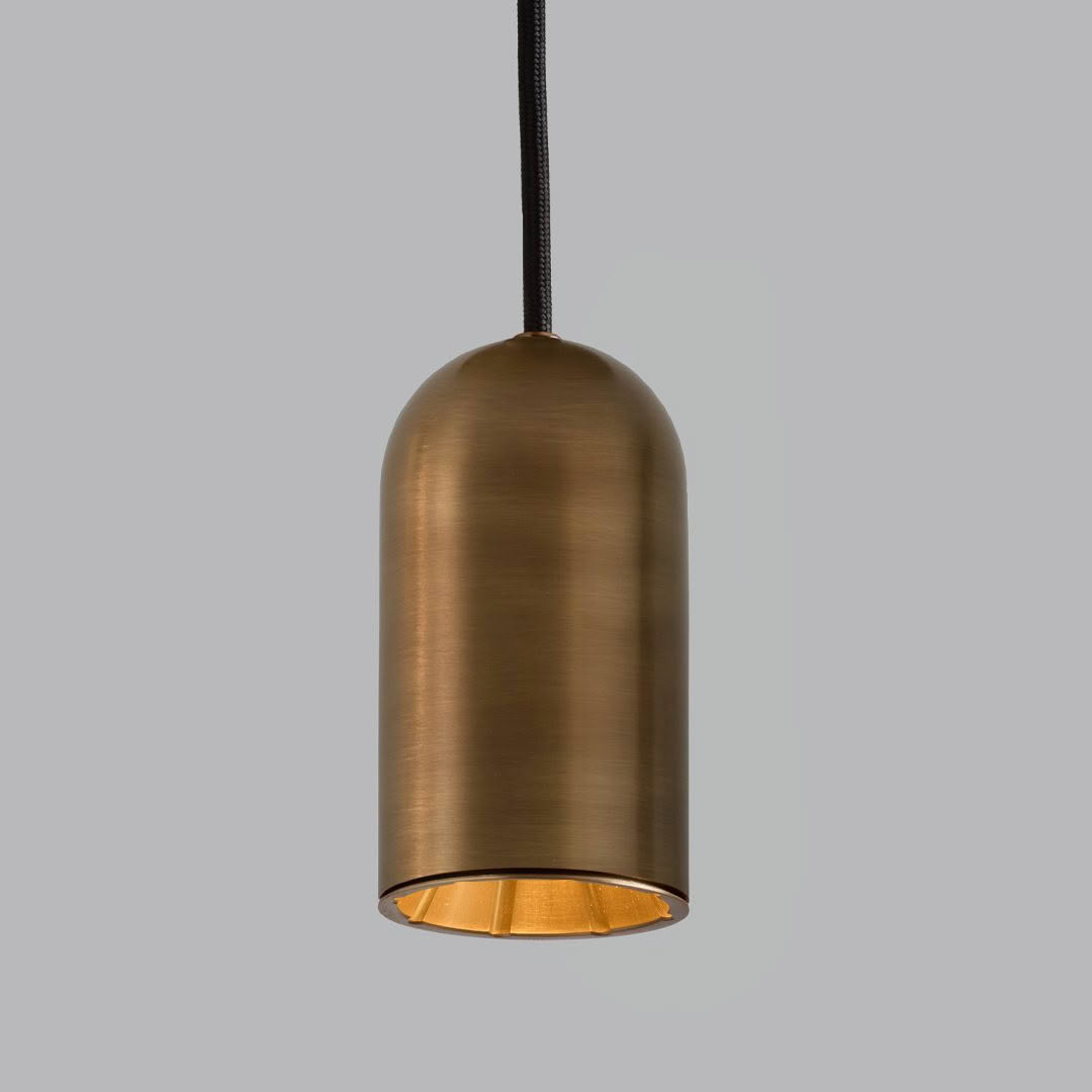 Bronze pendant light hanging against a gray background