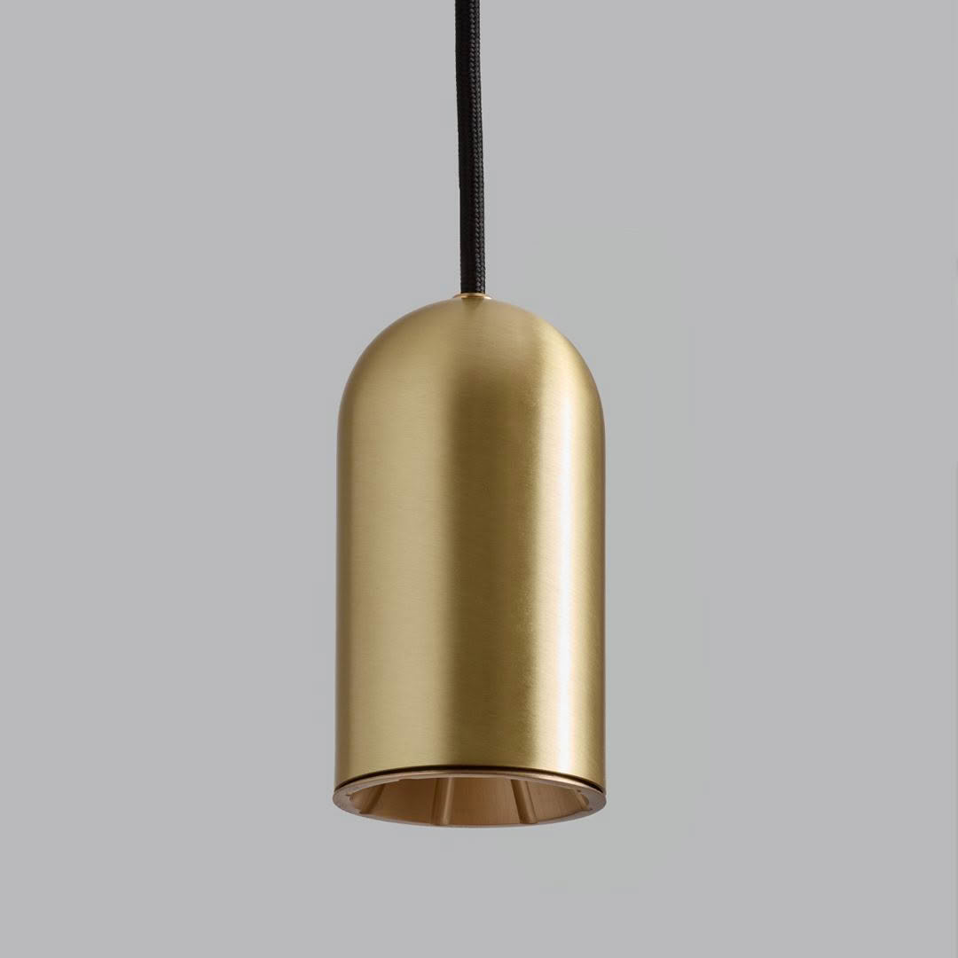 Gold cylindrical pendant light against gray background