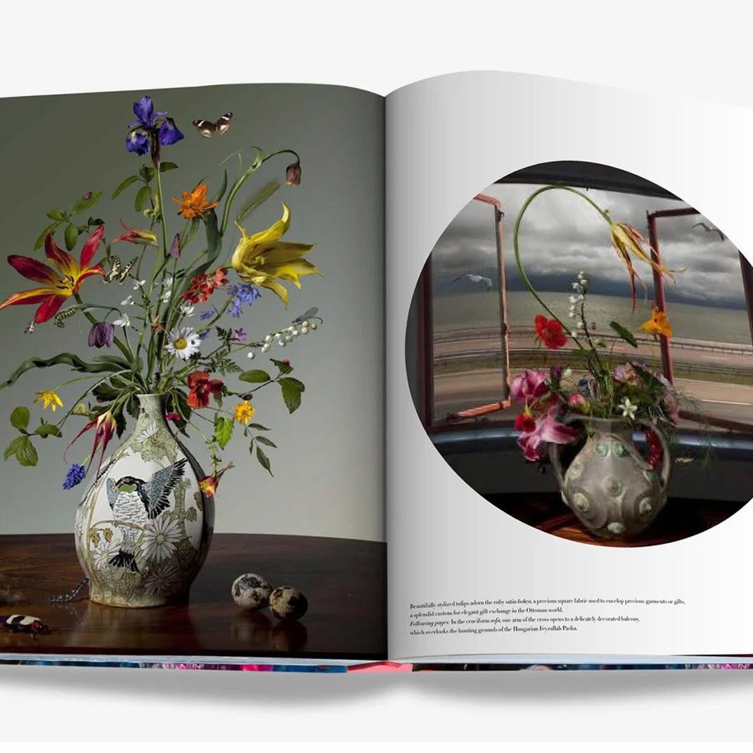 Open book displaying vibrant floral arrangements in vases