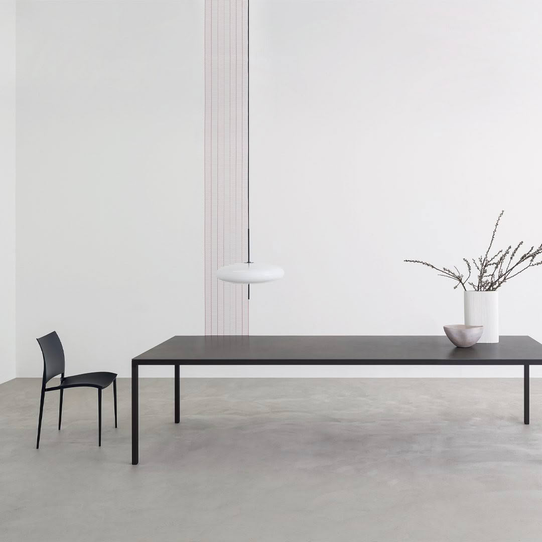 Minimalist room with black table, chair, and pendant light