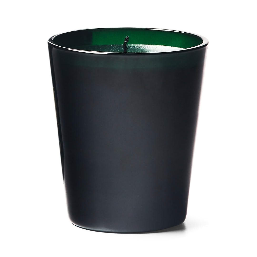 Black candle with green wax in sleek container