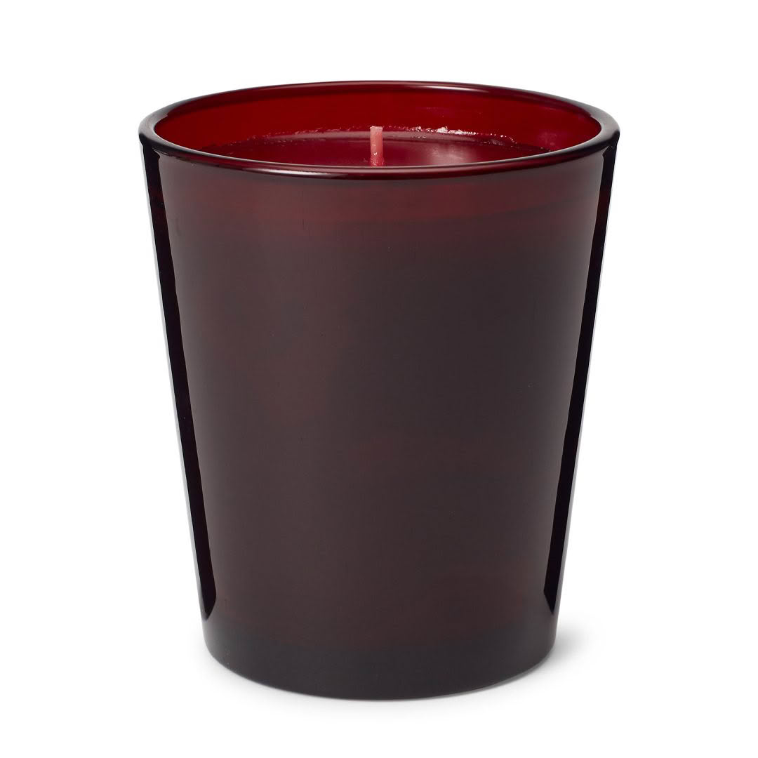 Red wax candle in dark glass jar