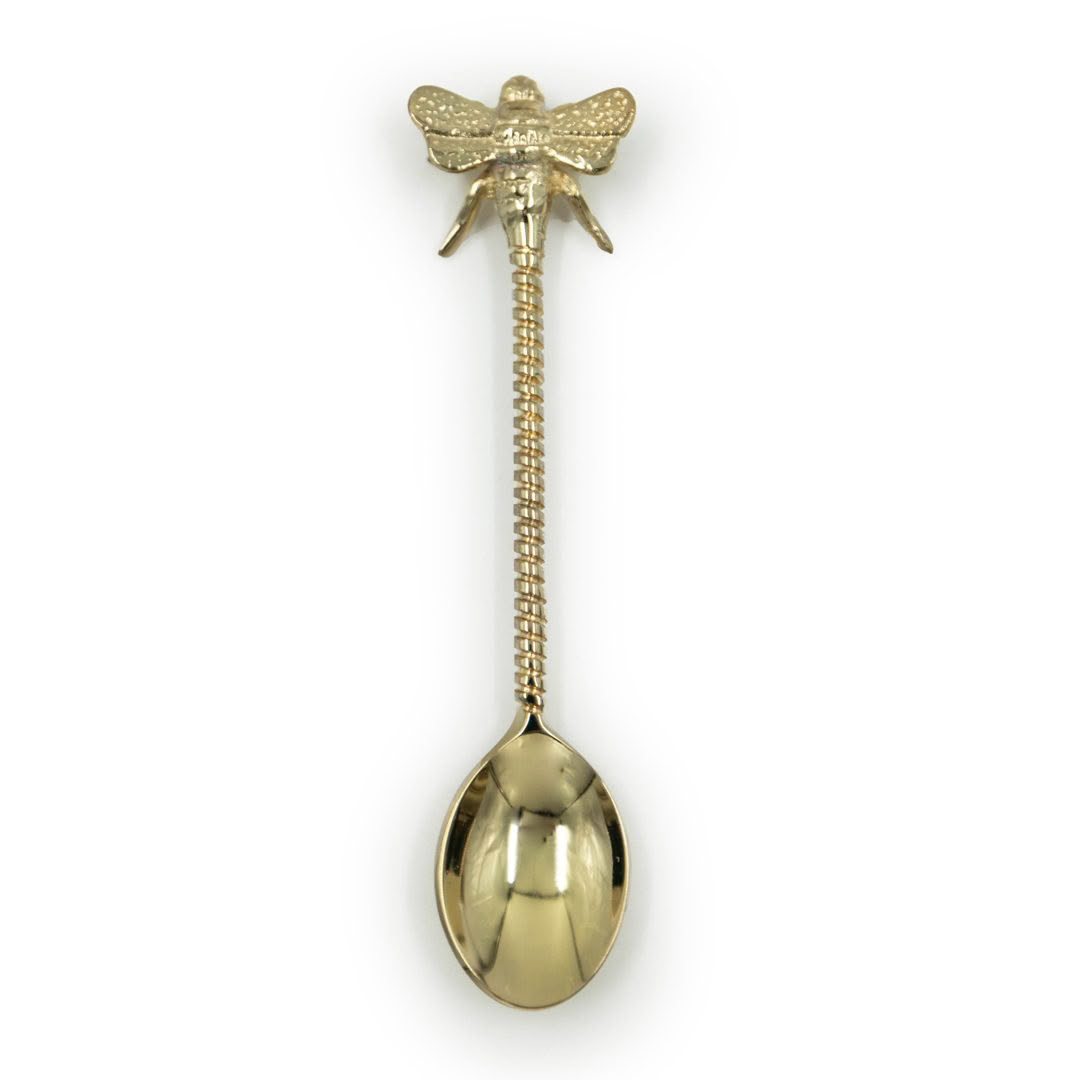Gold bee-shaped spoon on white background