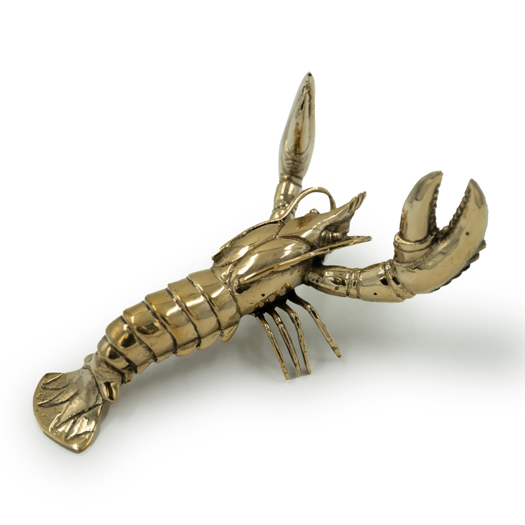 Golden metallic lobster sculpture on white background