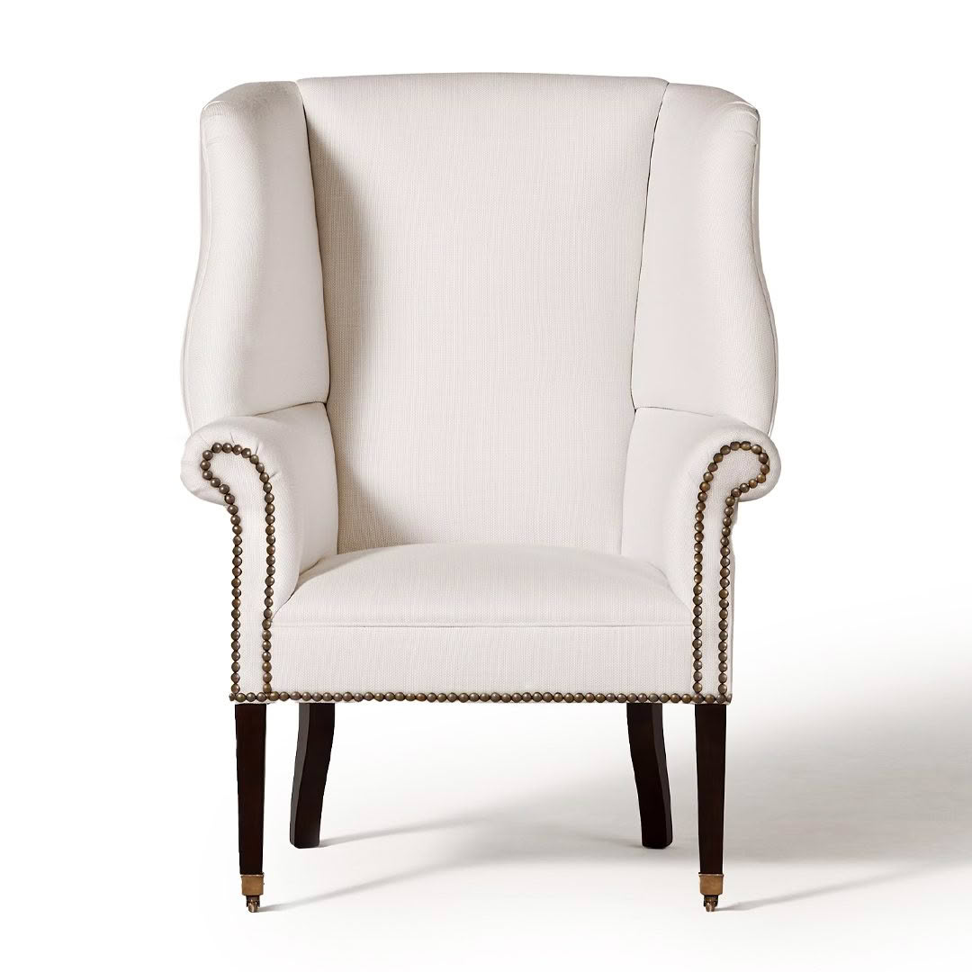 Elegant white wingback chair with dark wooden legs
