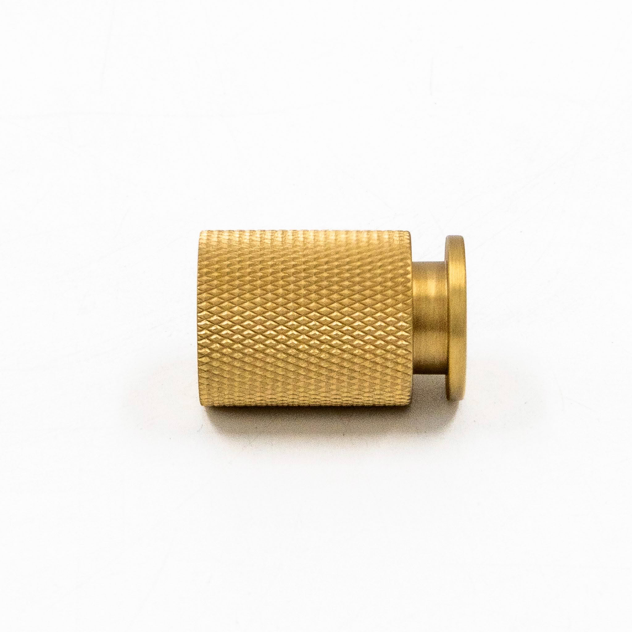 Gold textured cylindrical metal object on white background