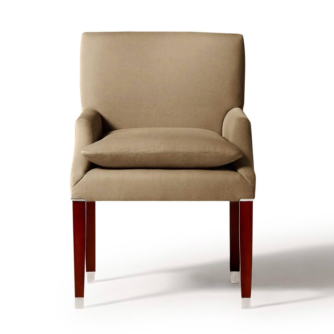 Beige upholstered armchair with wooden legs isolated on white