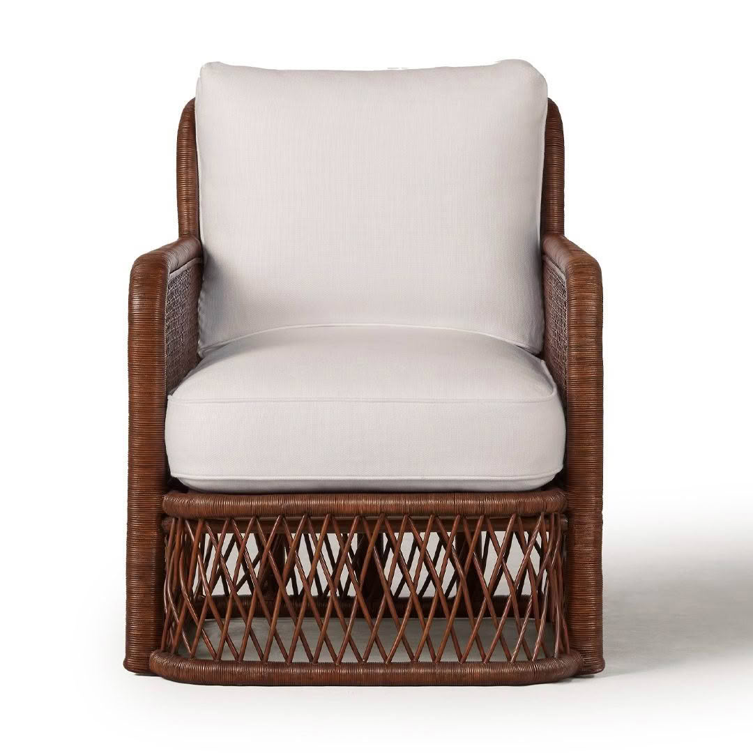 Brown wicker armchair with white cushions