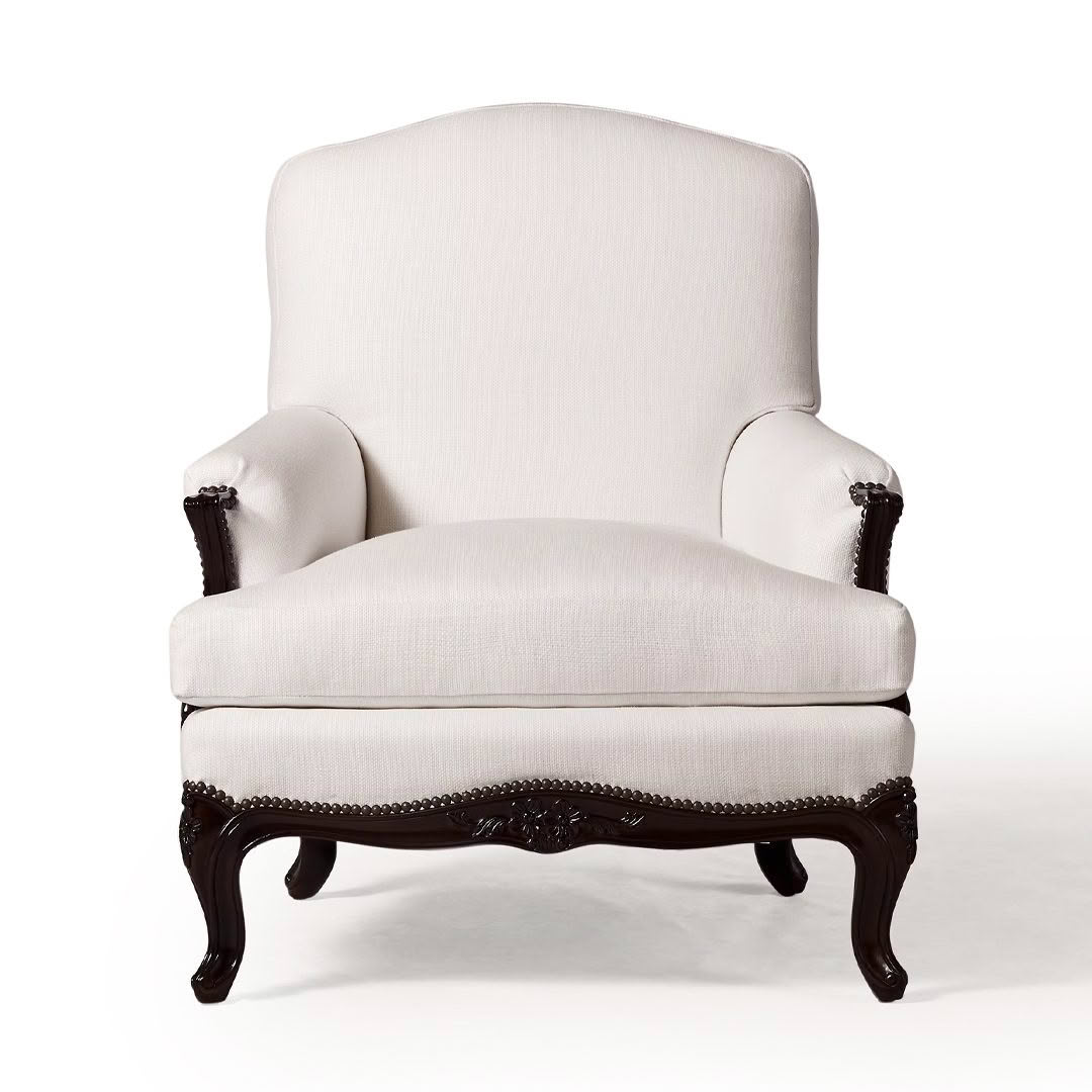 Elegant white upholstered armchair with dark wood trim