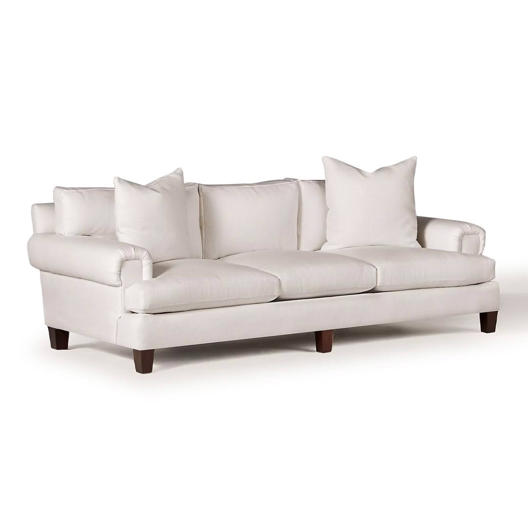 Elegant white three-seat cushioned sofa with pillows
