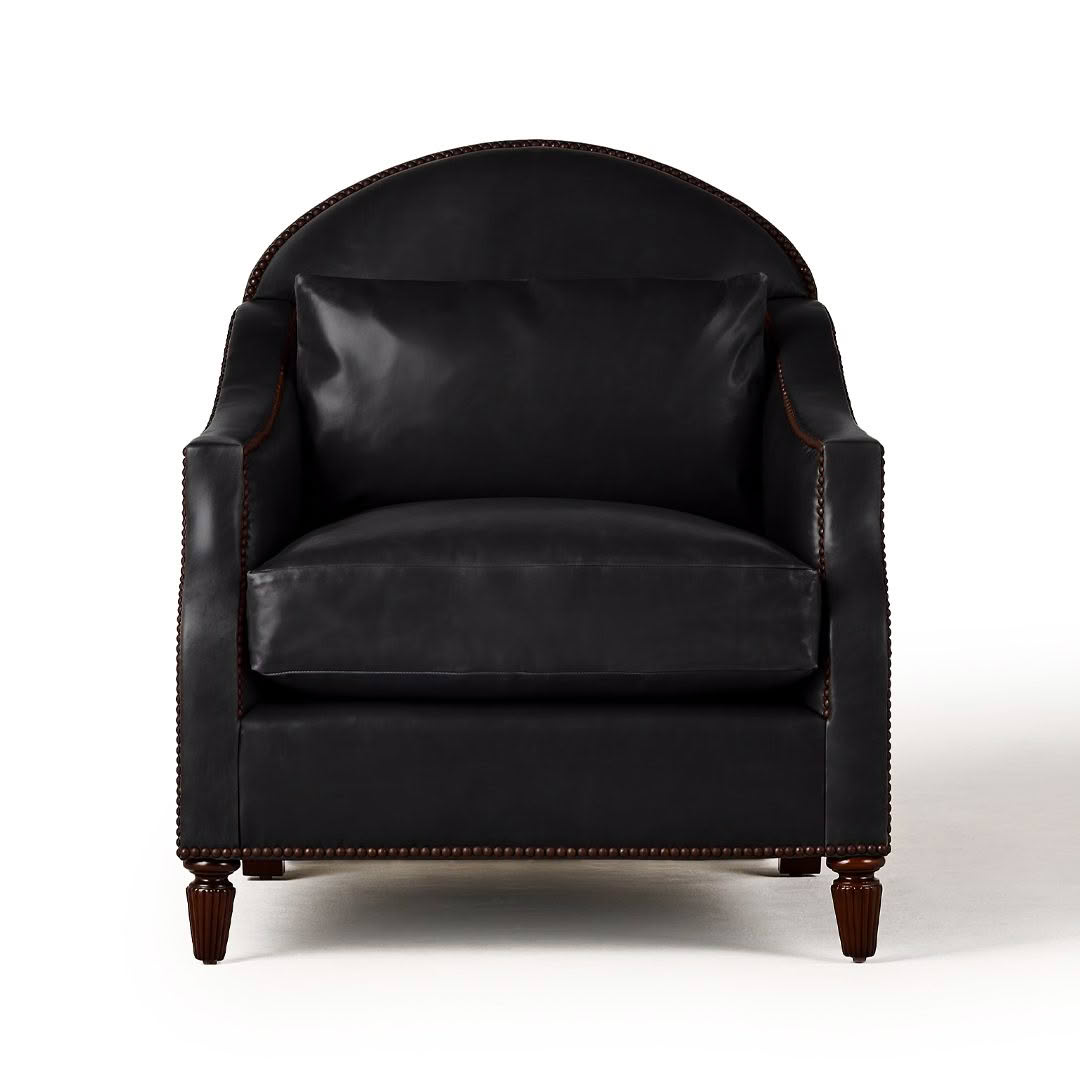 Elegant black leather armchair with wooden legs