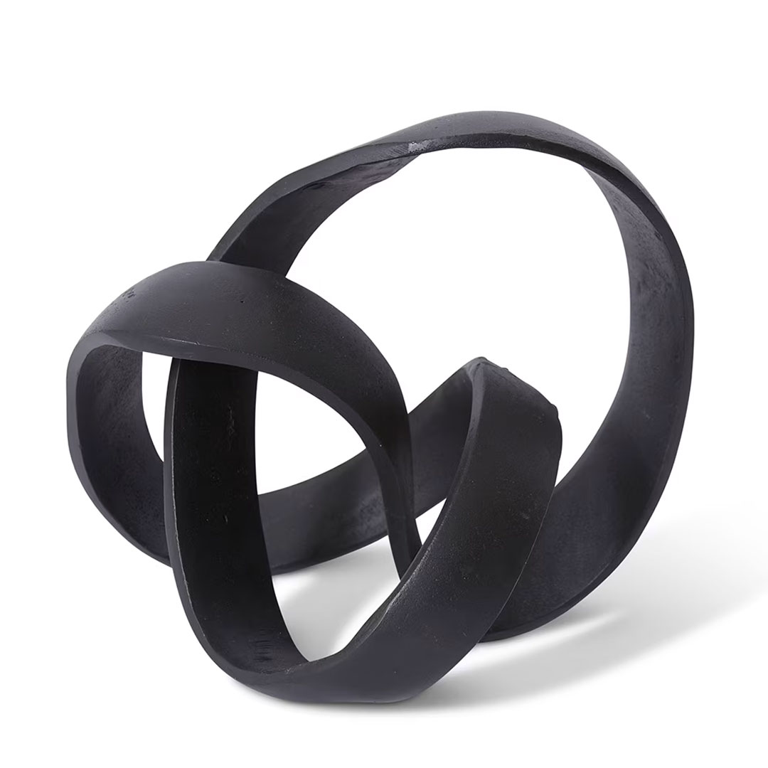 Abstract black intertwined metal sculpture on white background