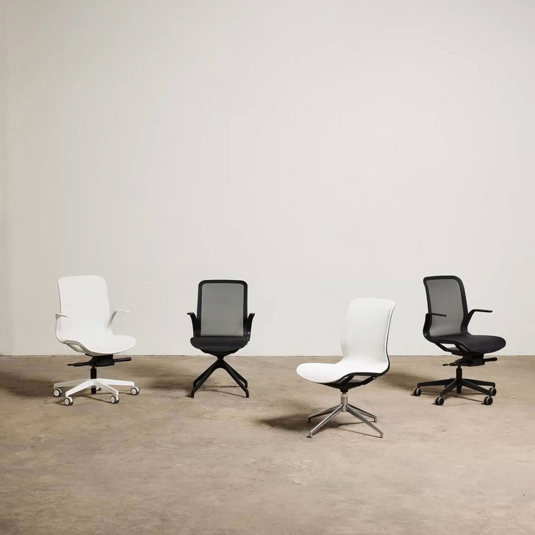 Four modern office chairs on a plain background