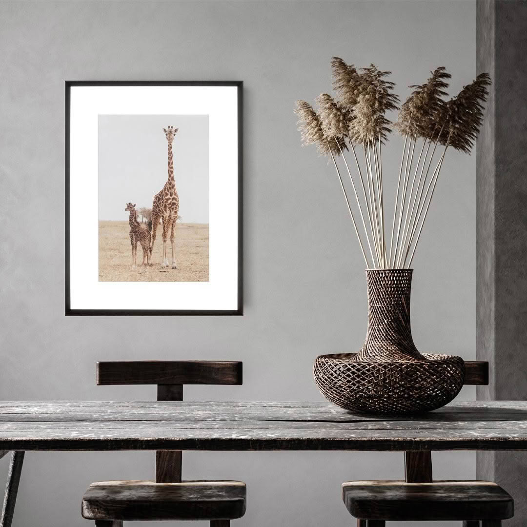 Giraffe portrait framed on wall above wooden bench