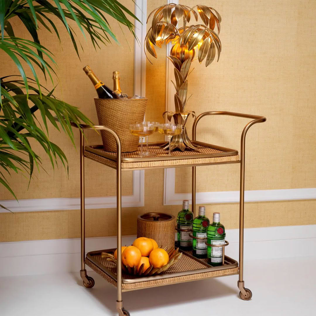 Elegant bar cart with drinks and golden palm lamp