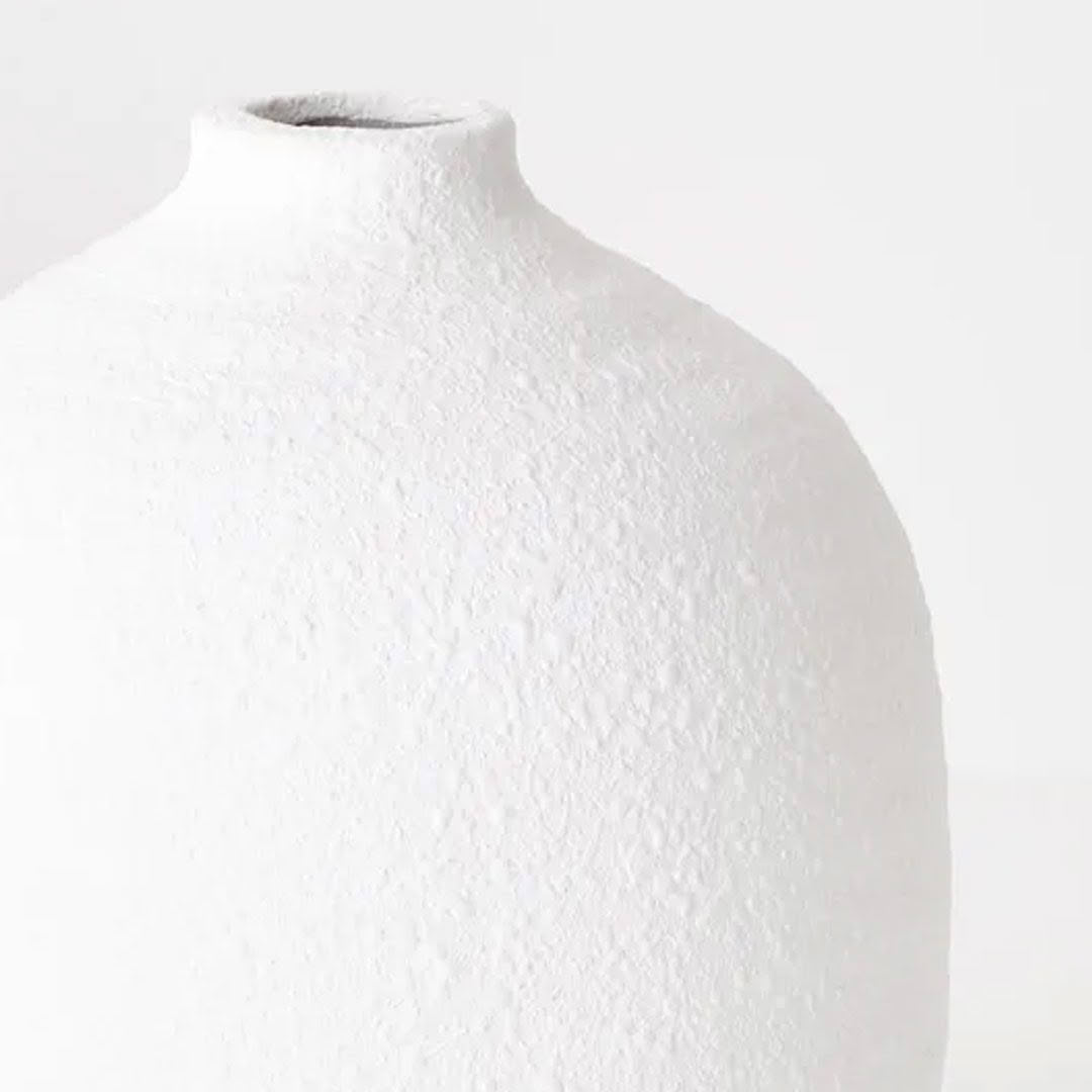 Textured white ceramic vase on light background