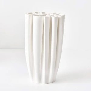 White vertical grooved ceramic vase on plain background