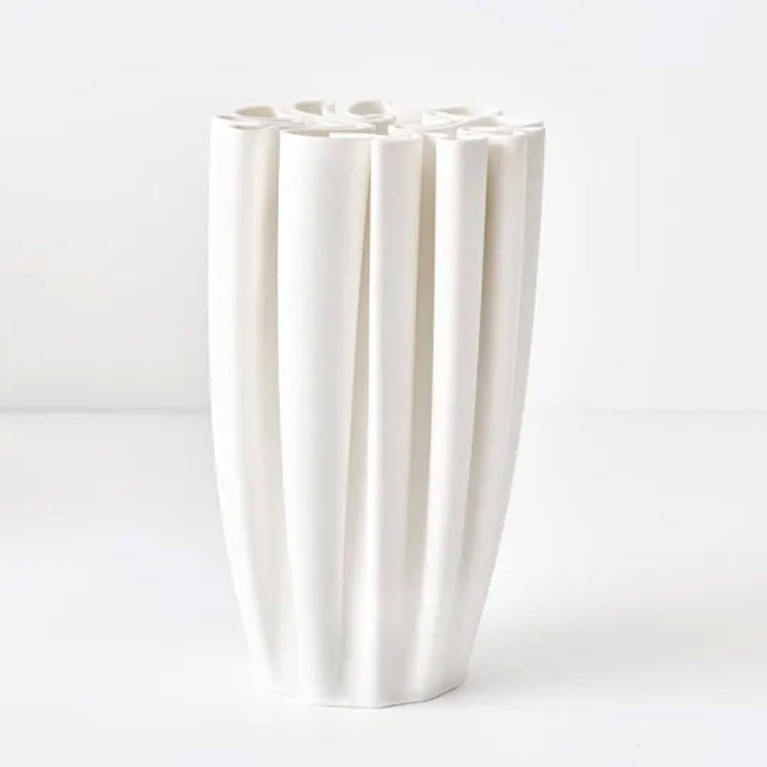 White vertical grooved ceramic vase on plain background