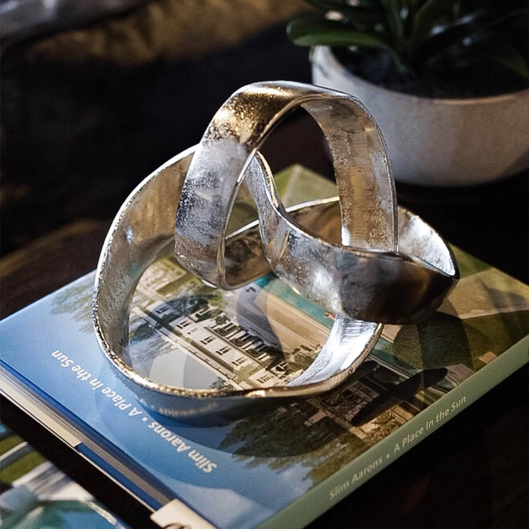 Silver abstract sculpture on a book about architecture.