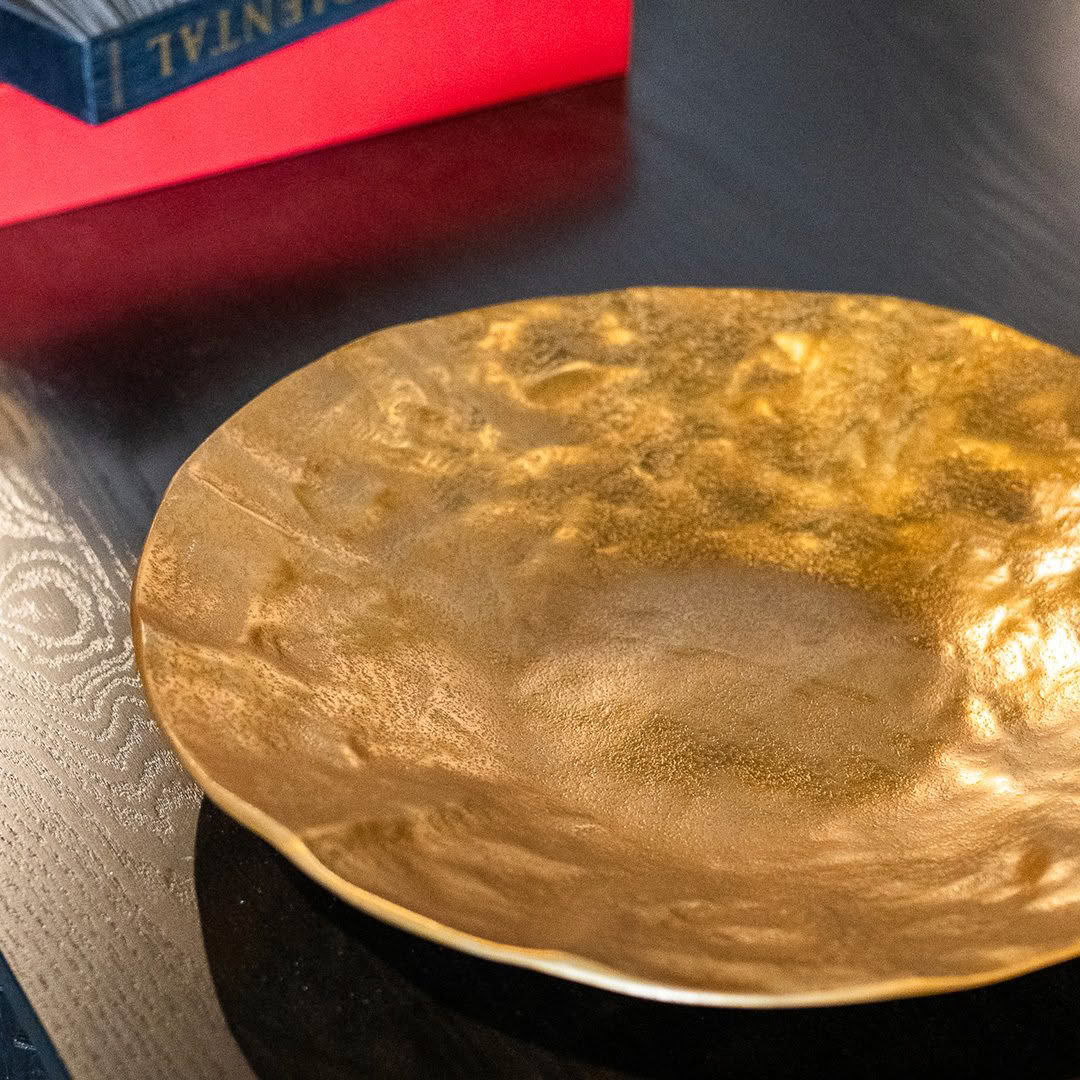 Golden textured decorative plate on a dark table
