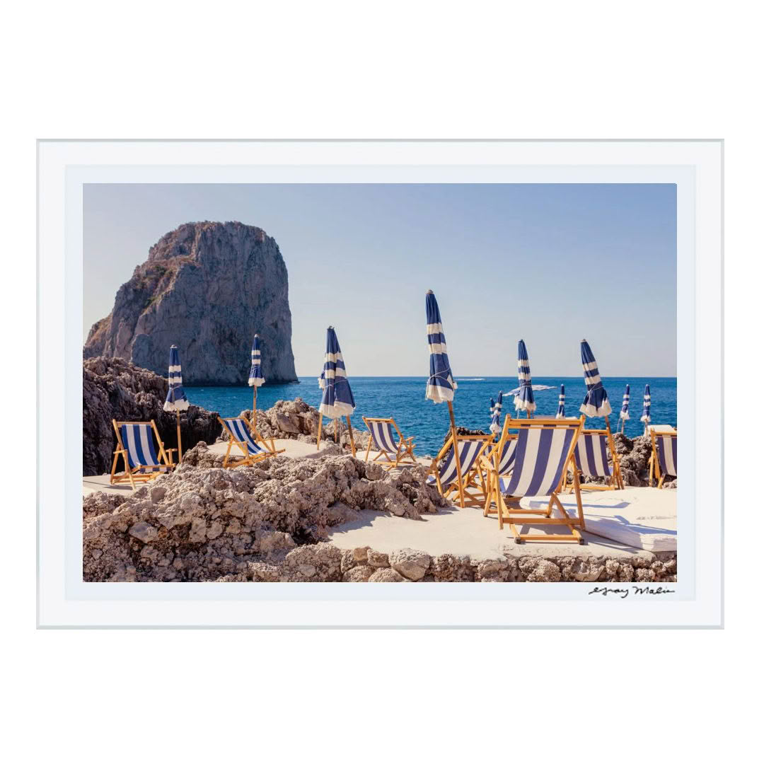Seaside loungers and umbrellas overlooking rocky cliff