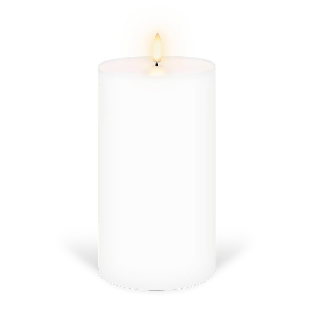 Lit white pillar candle on white background