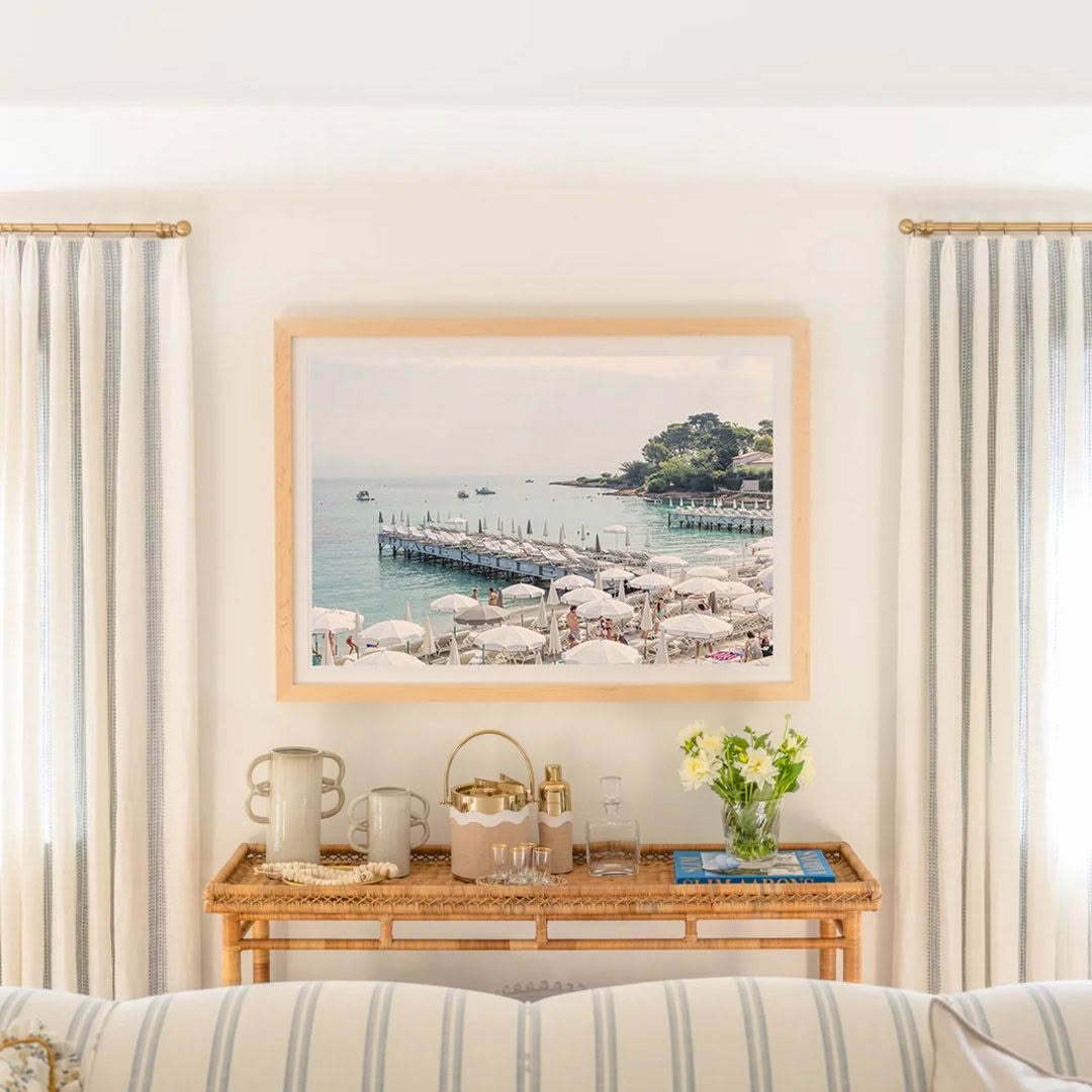 Cozy room with framed seaside painting and striped sofa