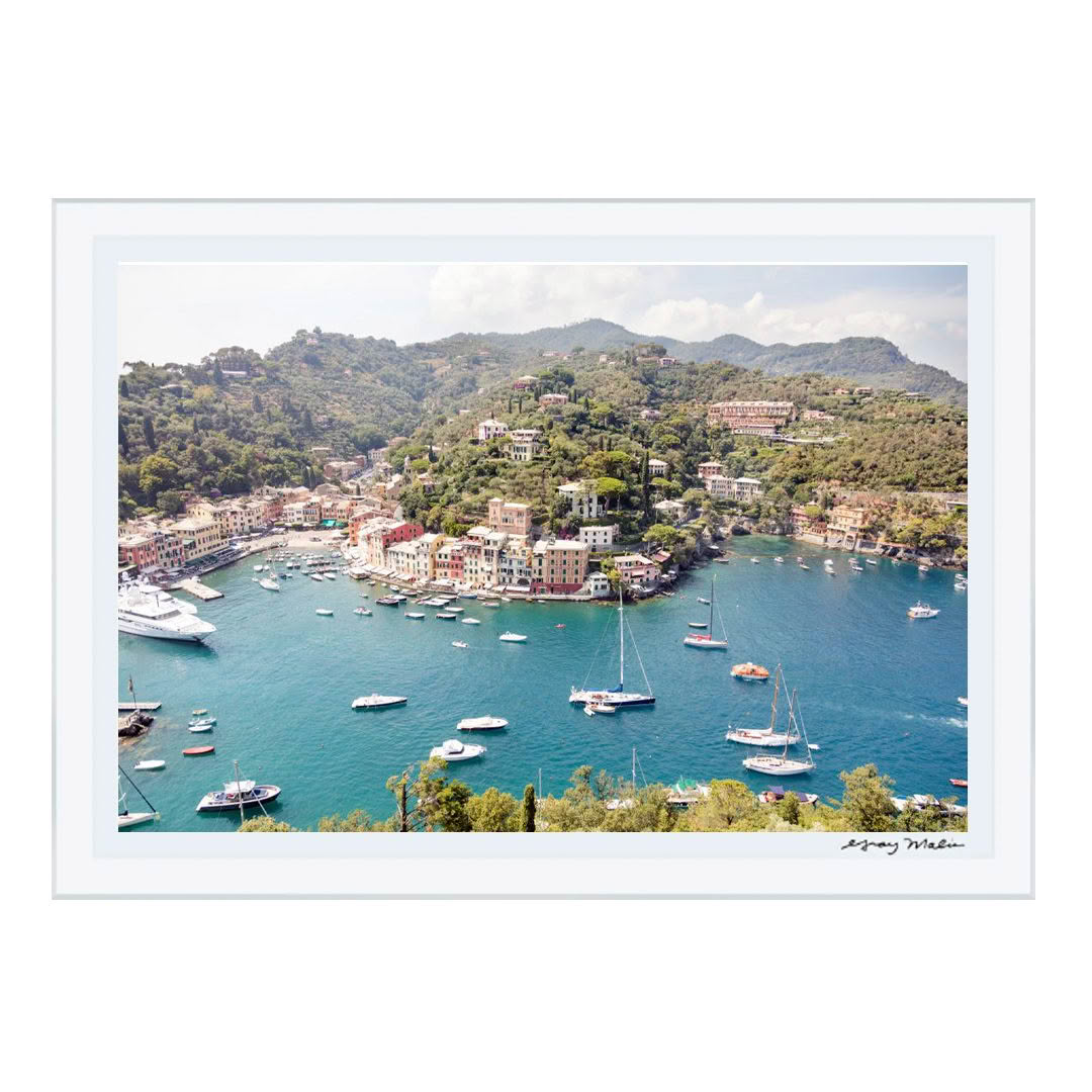 Aerial view of coastal village with boats and green hills