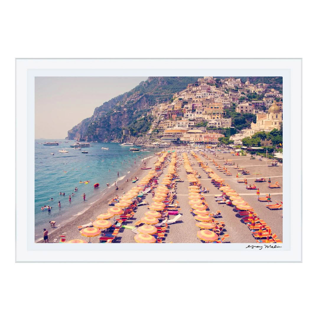 Colorful beach umbrellas along a crowded coastal town