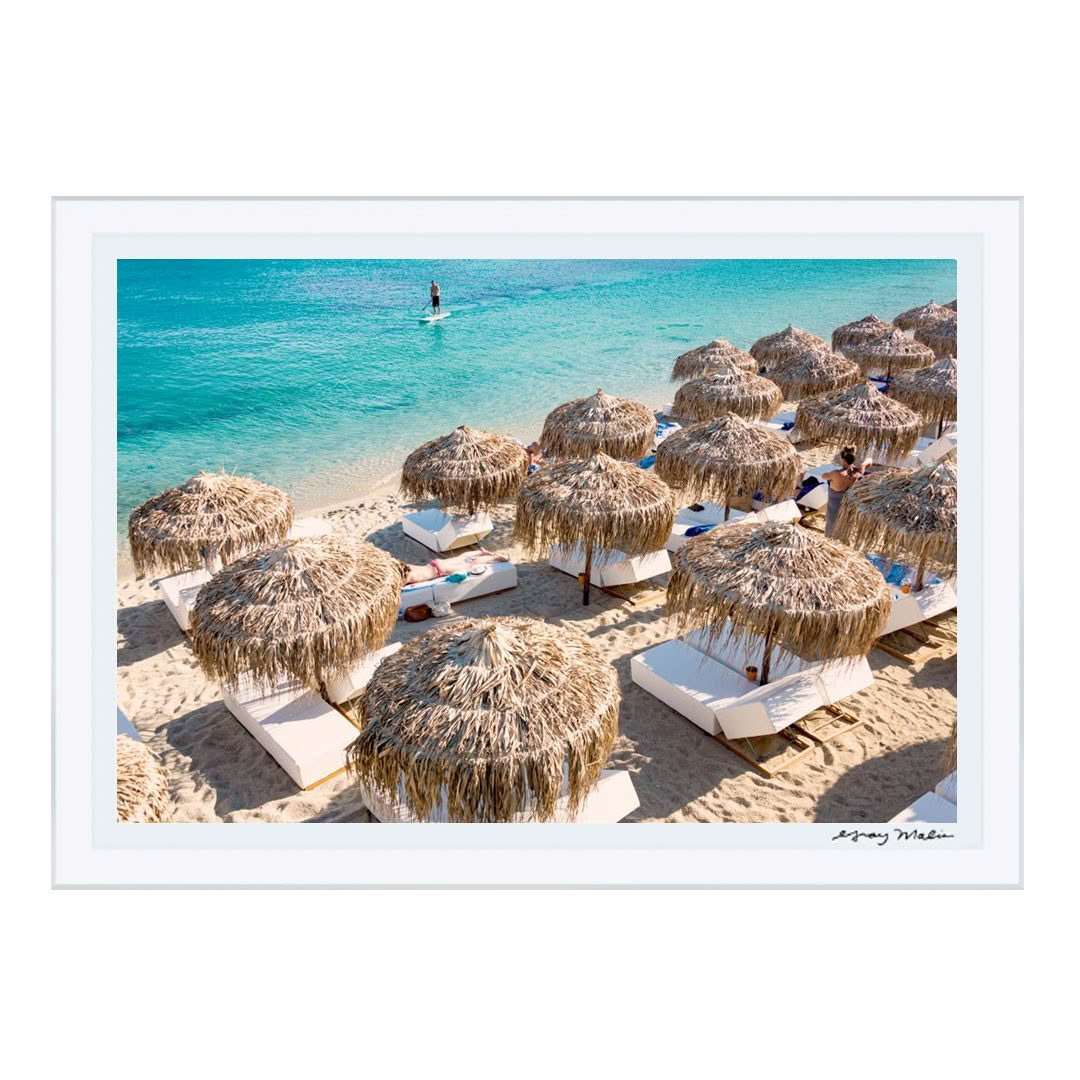 Beachside view with straw umbrellas and loungers