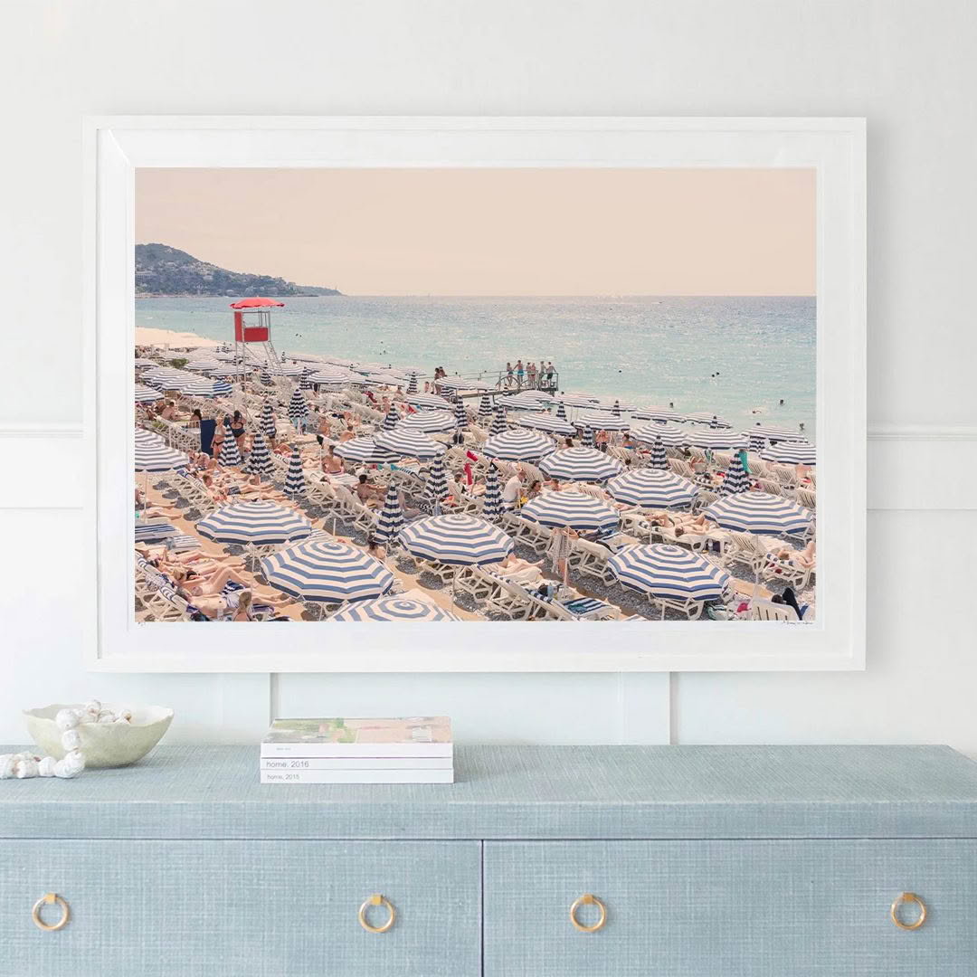 Framed beach print with striped umbrellas and bustling crowd