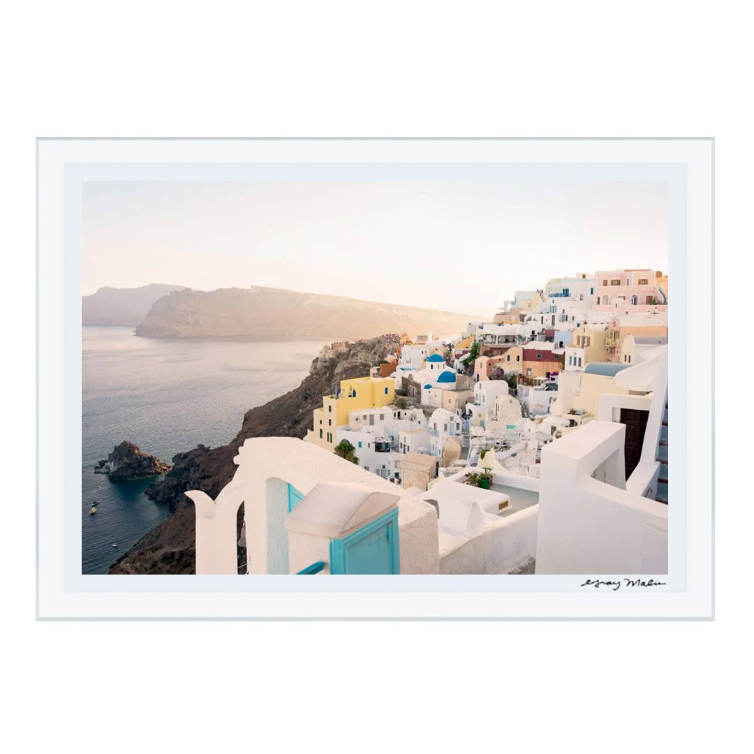 Santorini cliffside village overlooking blue sea at sunset