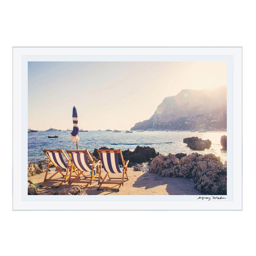 Beach chairs by sea at sunset