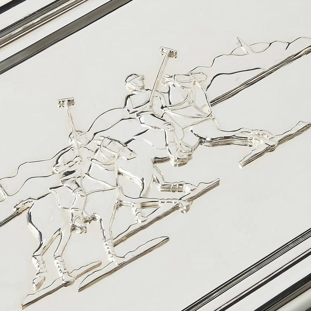 Metallic sculpture of three skiing figures on slope