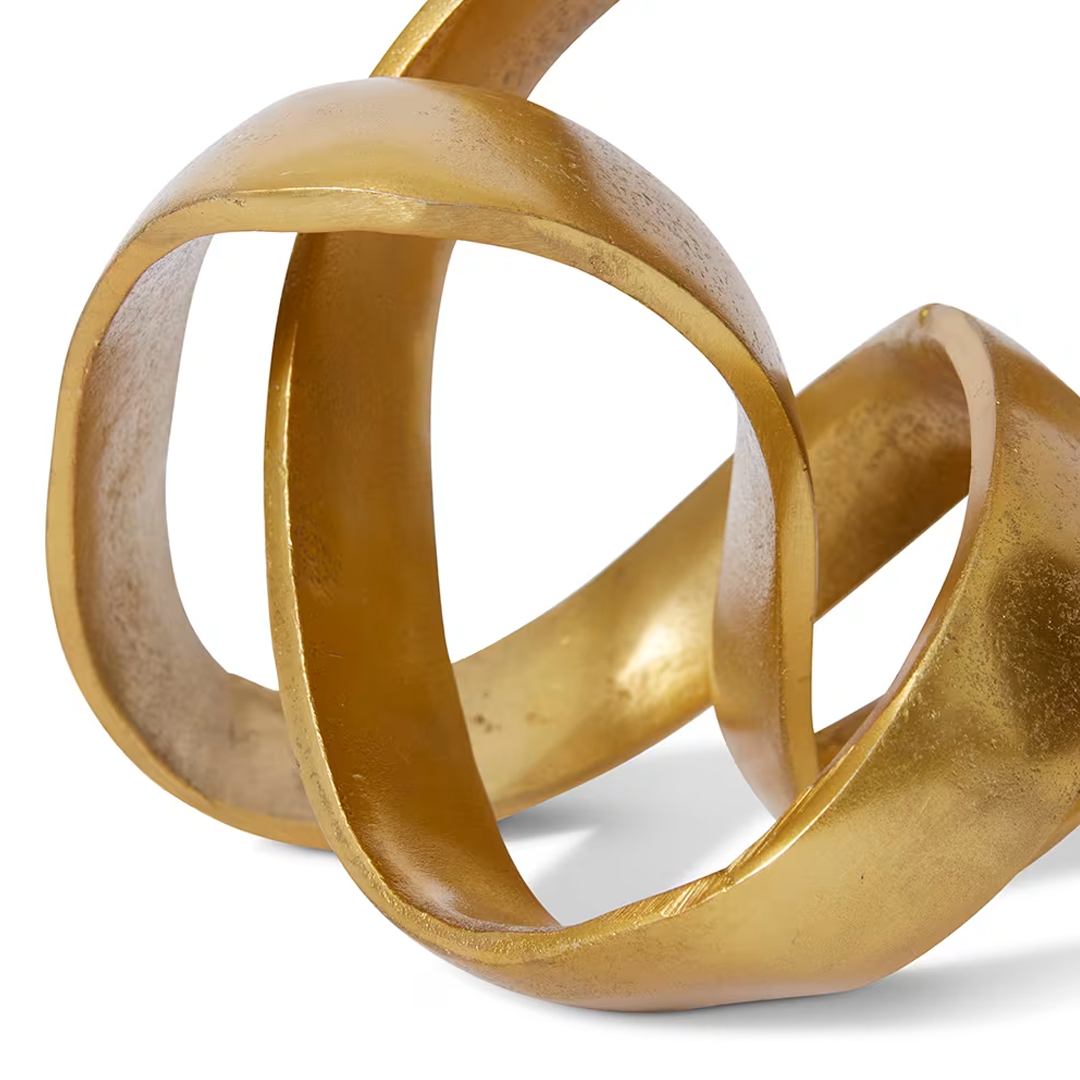 Interlocking golden metallic sculpture on white