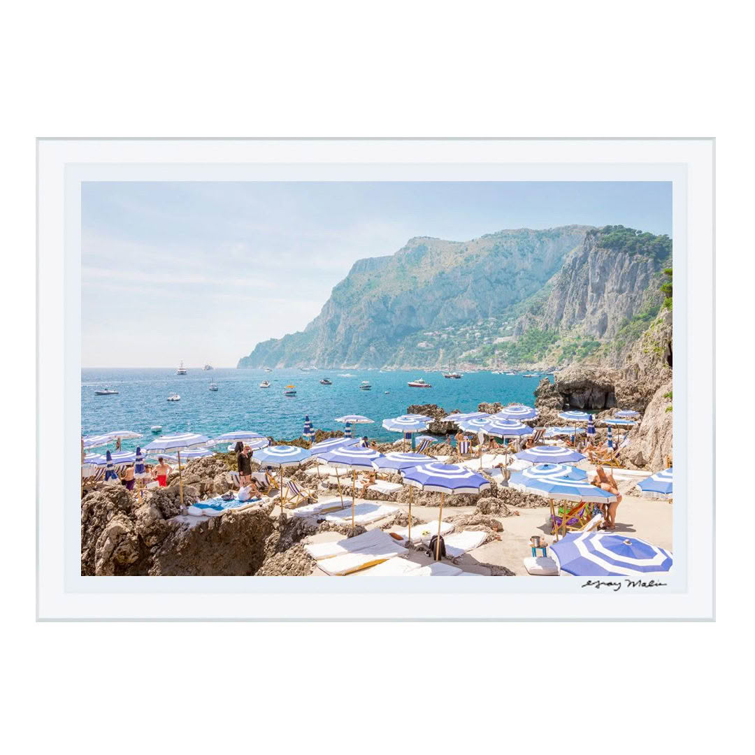 Sunny coastal beach scene with umbrellas and cliffs