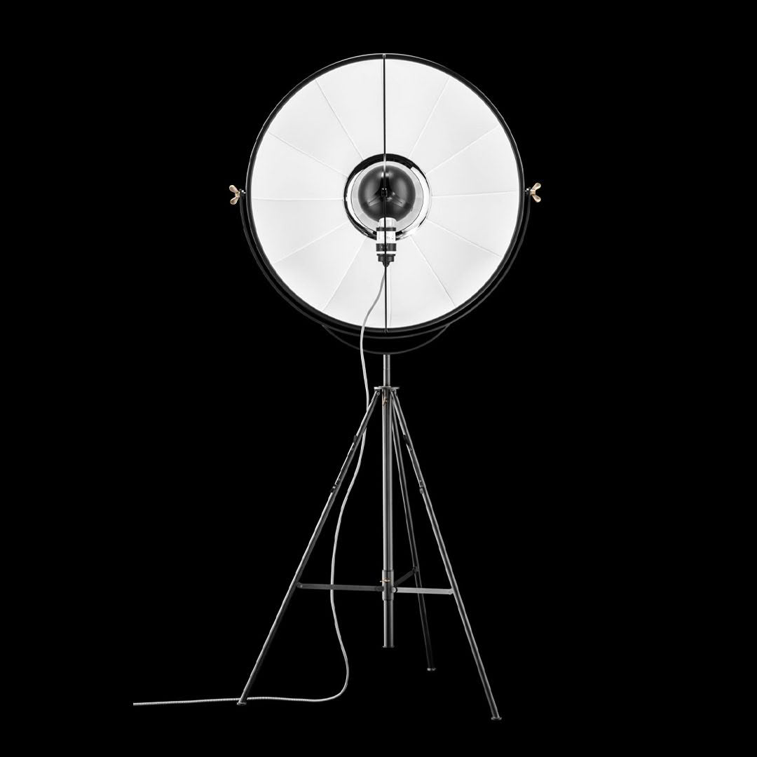 Professional studio light on tripod against black background