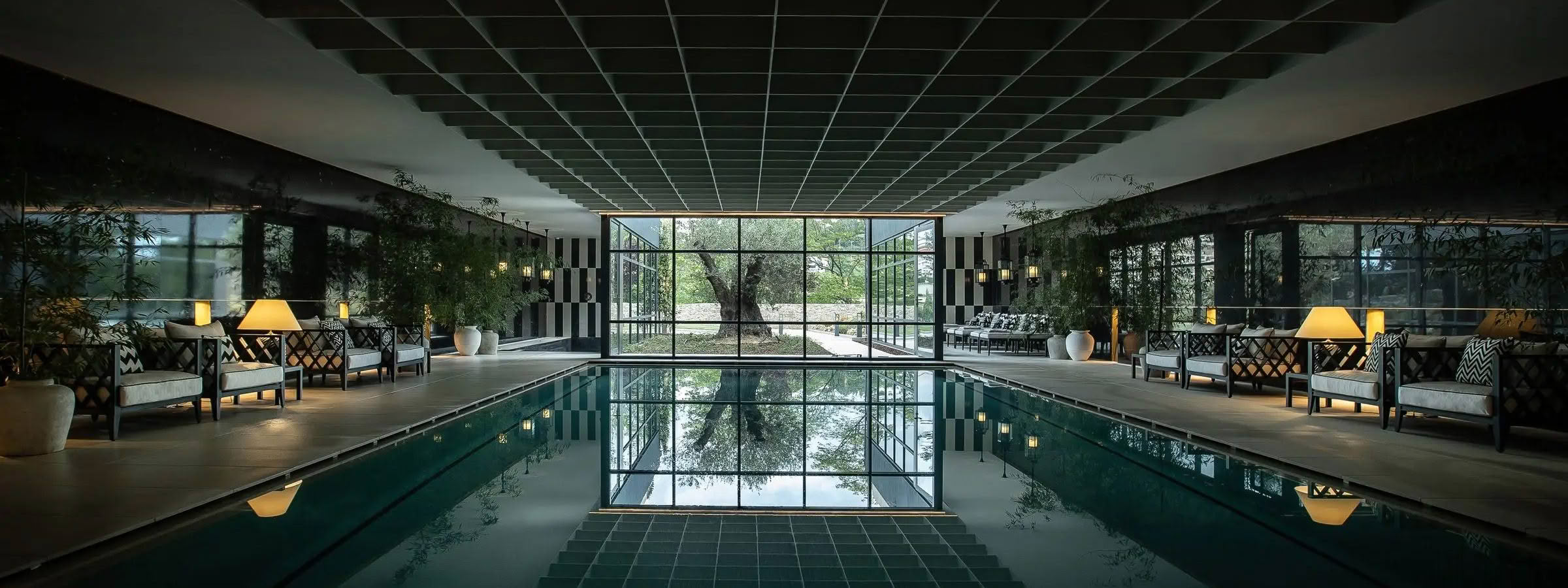 Elegant indoor pool with reflective water and seating area