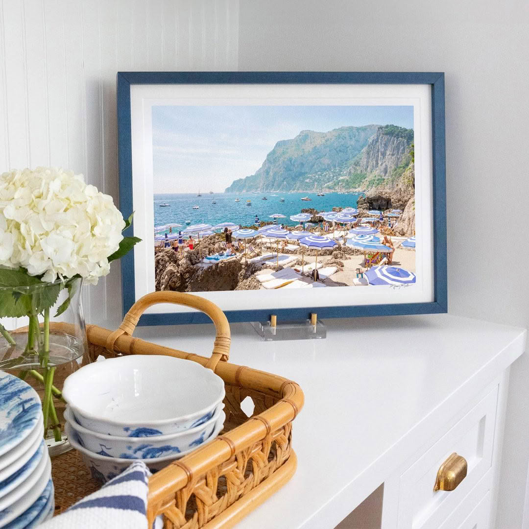 Seaside framed photo on dresser beside flowers
