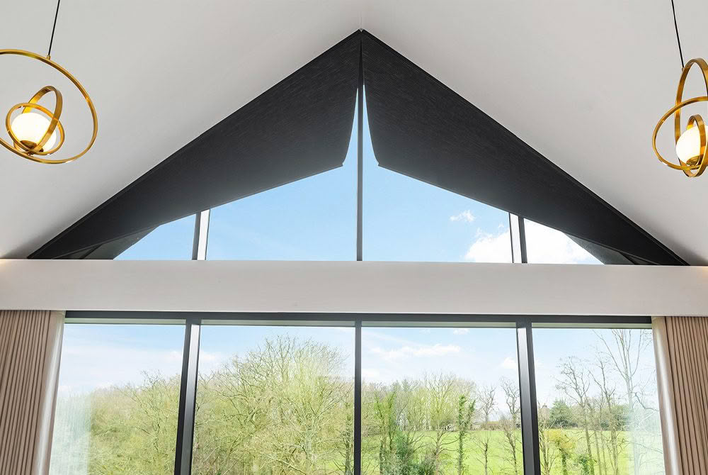 Modern interior with large triangular window and garden view