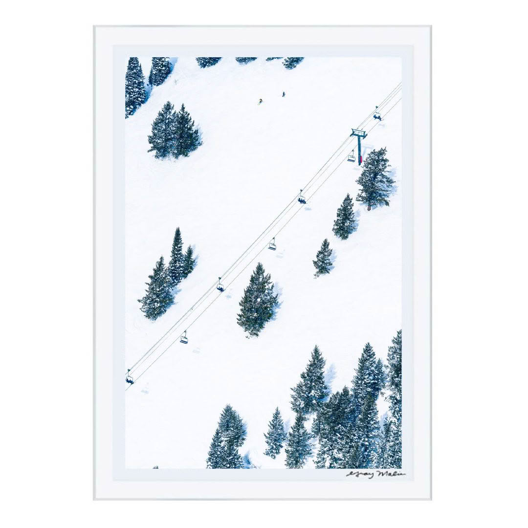 Snowy ski slope with chairlift and pine trees