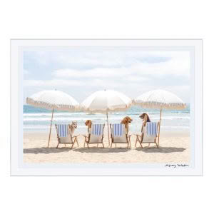 Dogs lounging under umbrellas on sandy beach