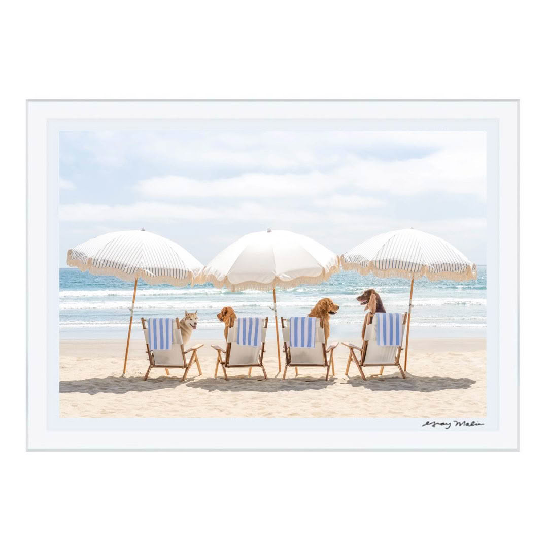 Dogs lounging under umbrellas on sandy beach