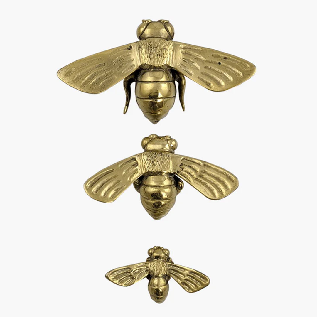 Three golden bee sculptures in descending size