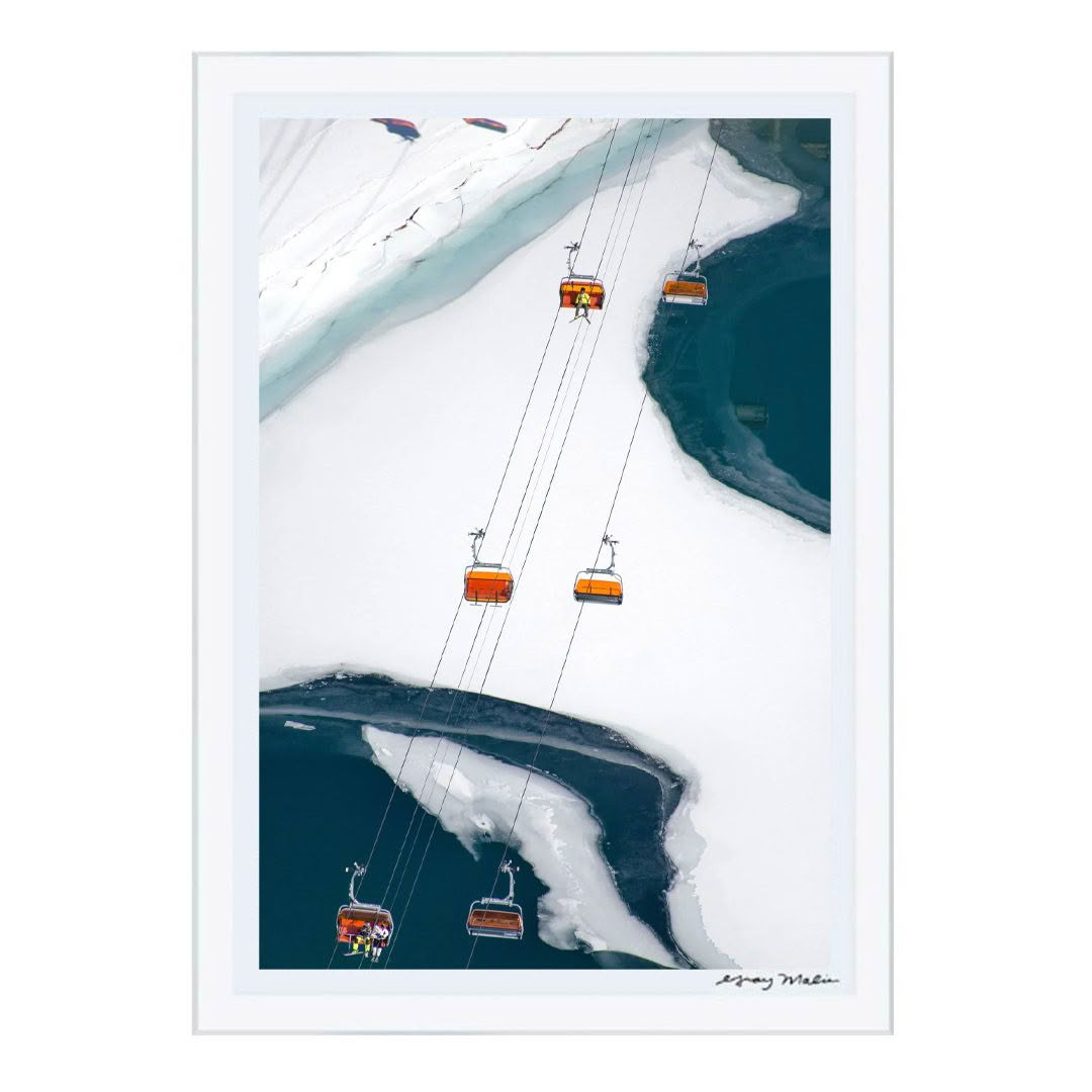 Aerial view of cable cars over snowy mountain crevasse