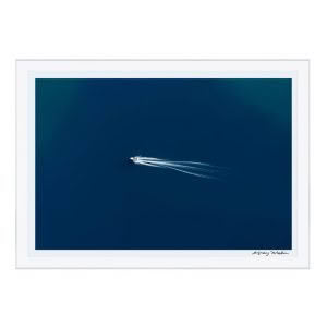 Boat leaving white trail on deep blue ocean